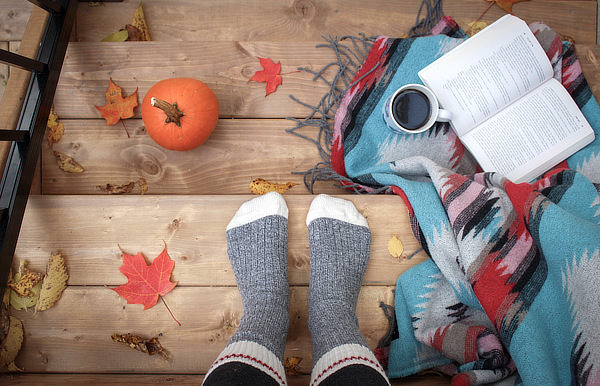 A fall scene (feet in wool socks, pumpkin, blanket, and coffee)