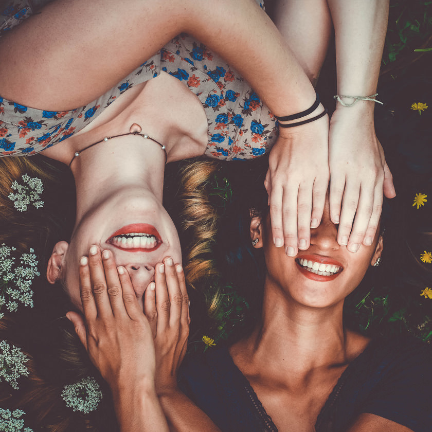 Photo: Two smiling women covering each other's eyes